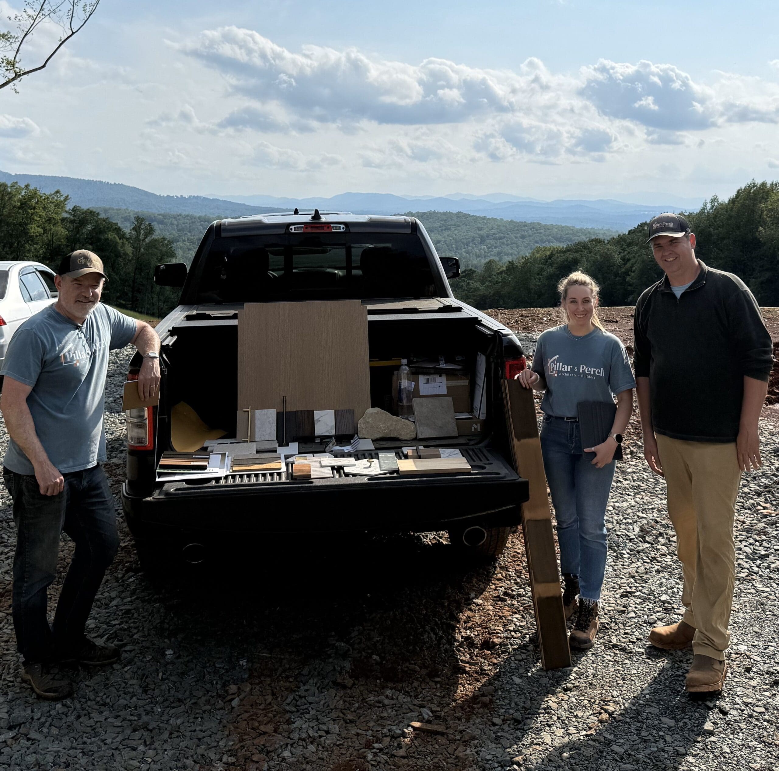 Nick, Dani, and Ben from Pillar & Perch standing at a truck with the material selections at the home job site.