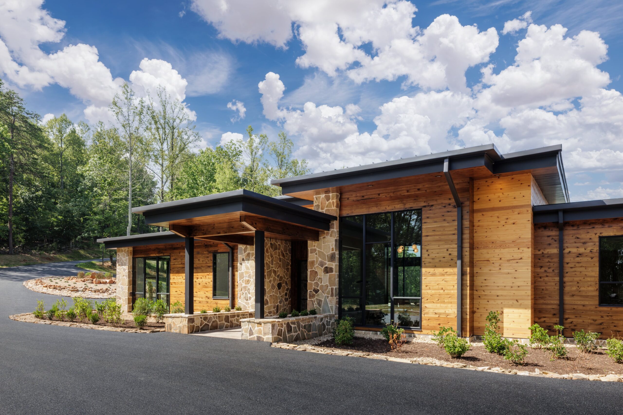 organic modern project exterior with rich cedar wood, stone, and natural materials so that the home appears like it belongs in the landscape
