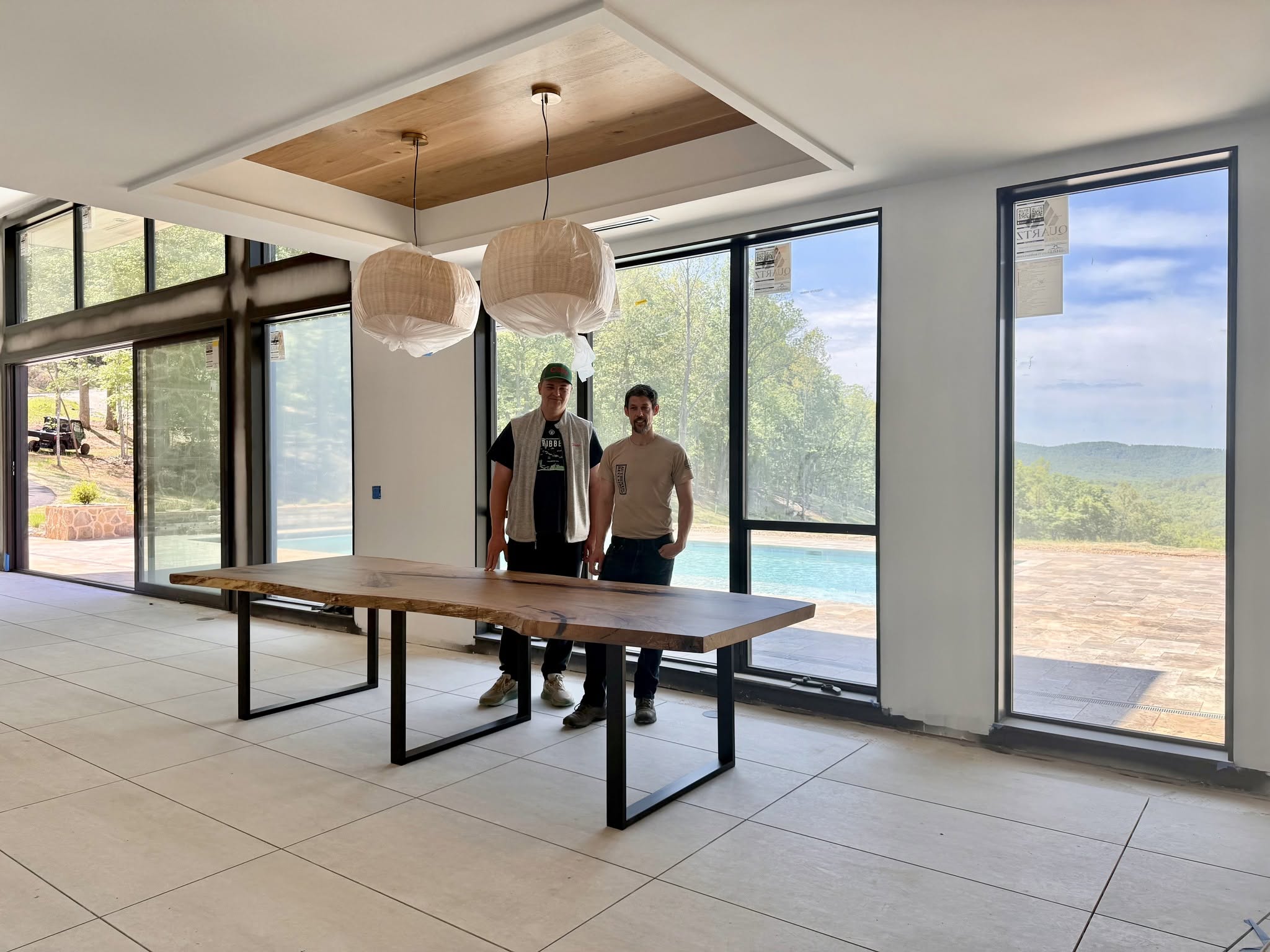 Ben of Pillar & Perch and Jason of Appalachian Woods stand behind the completed live edge table when it was first installed in the dining room