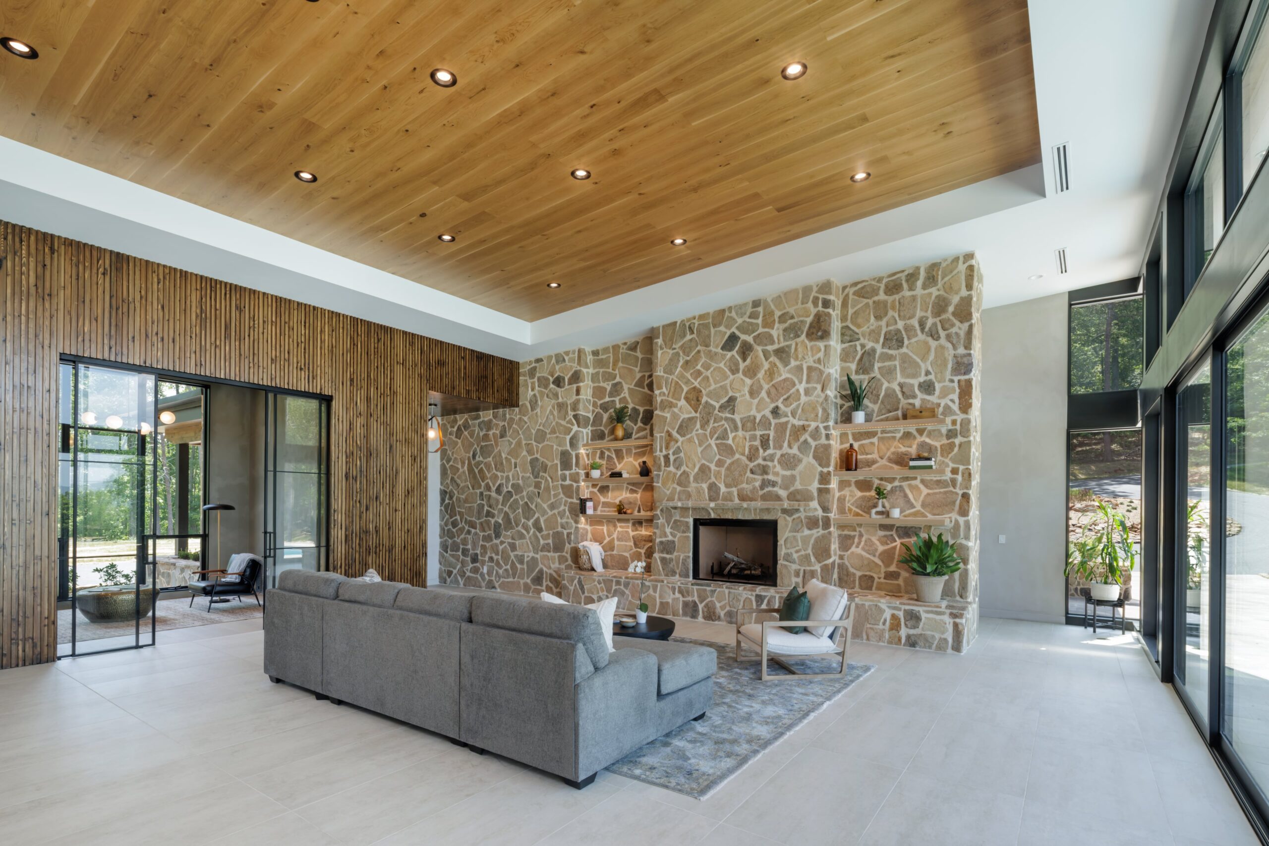 organic modern living room with couch and custom stone fireplace with floating shelves